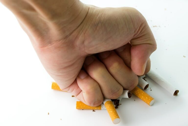 Main écrasant des cigarettes, symbole fort de l’arrêt du tabac et de la lutte contre la dépendance